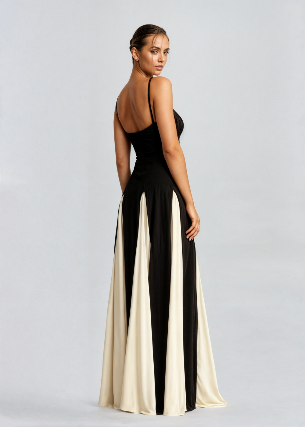 Woman wearing a black and white evening gown on a gray background